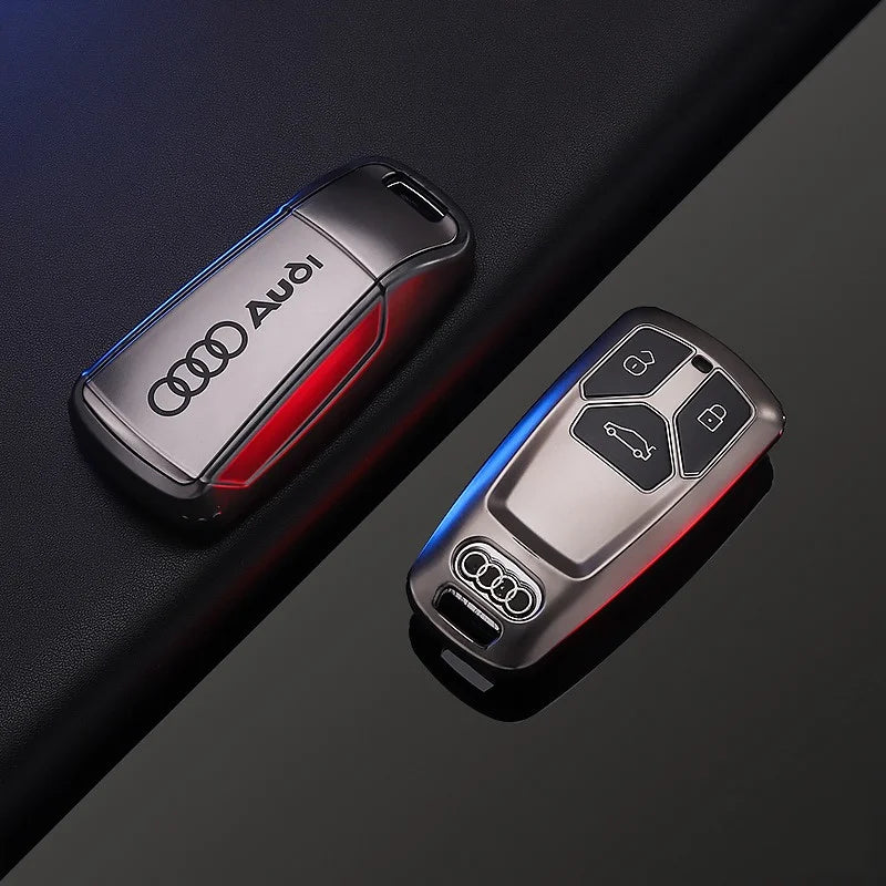 Two Audi car key fobs on a dark background