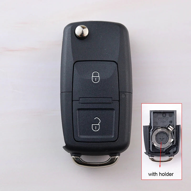 Black car key fob with inset showing key blade and holder on a white background