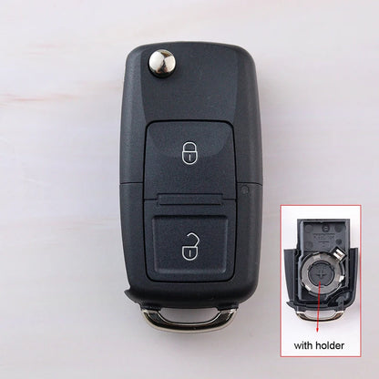 Black car key fob with inset showing key blade and holder on a white background