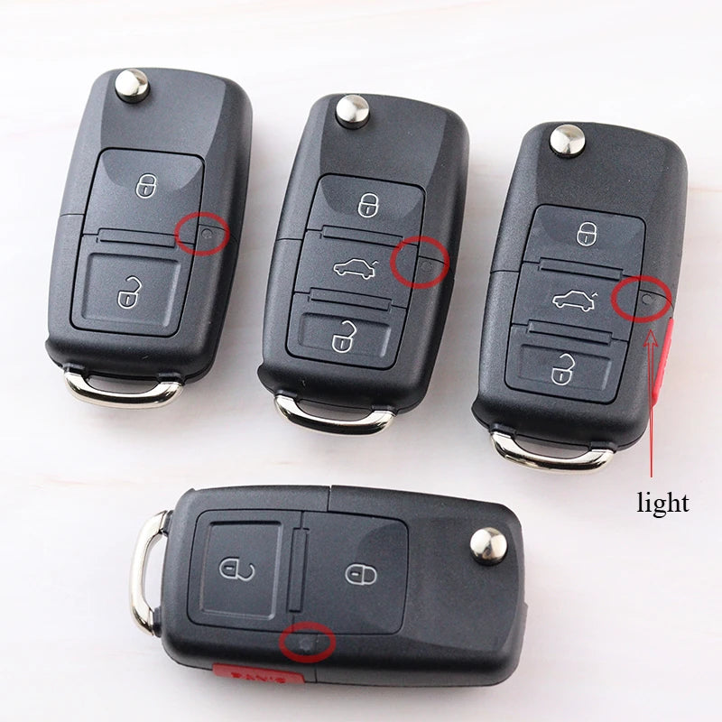 Four car key fobs with highlighted buttons on a white background