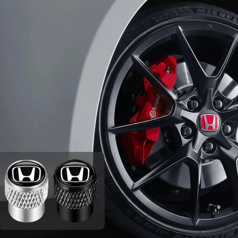 Honda tire valve caps with a Honda logo on a car wheel background