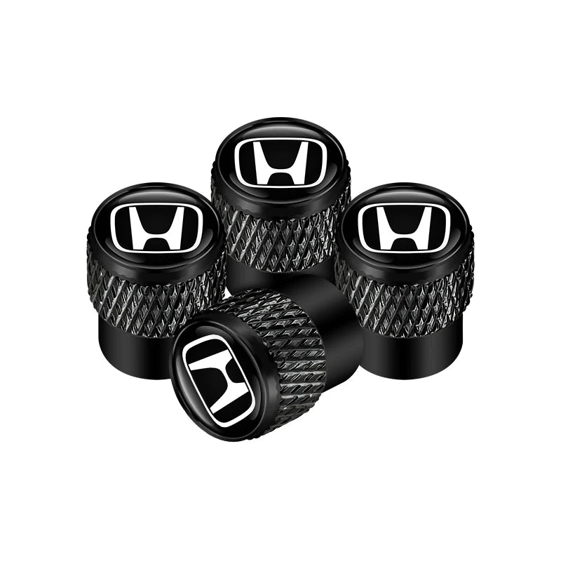 Set of black Honda logo valve stem caps on a white background